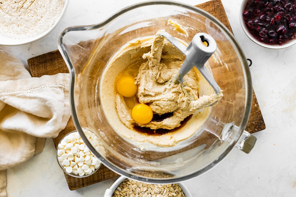 creaming butter and sugars together in mixing bowl and adding eggs and vanilla extract. 