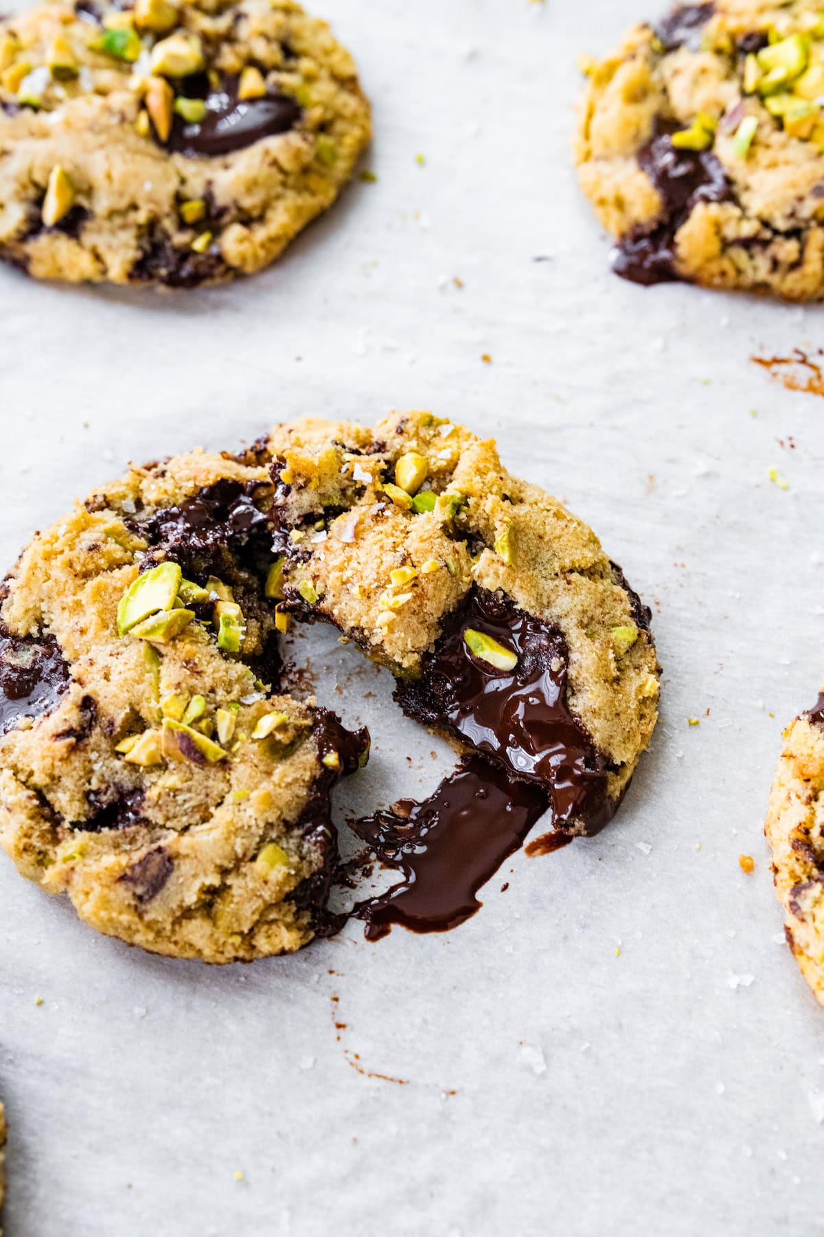 dark chocolate pistachio cookie broken in half. 