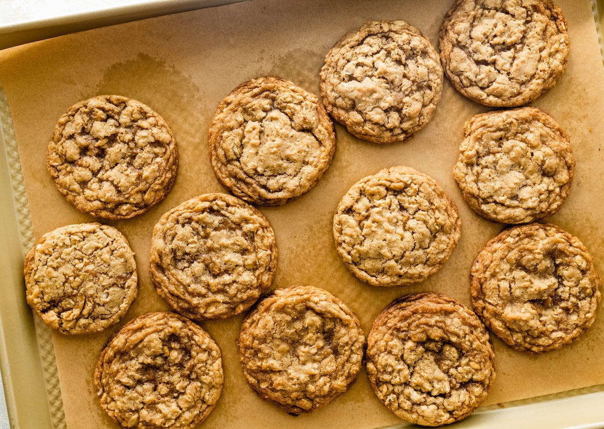 iced oatmeal cookies on baking sheet with parchment paper. 