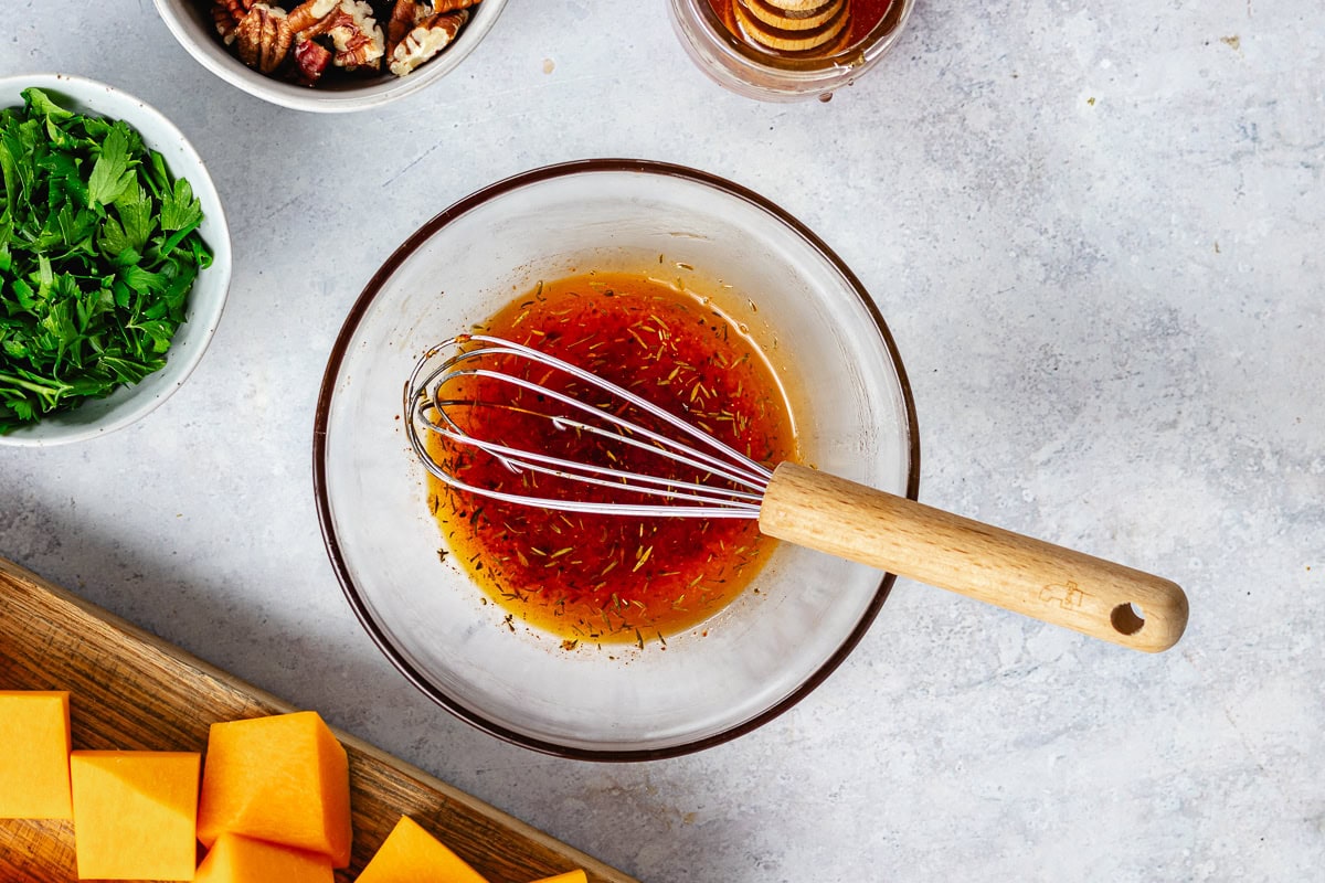 hot honey dressing in bowl with whisk. 