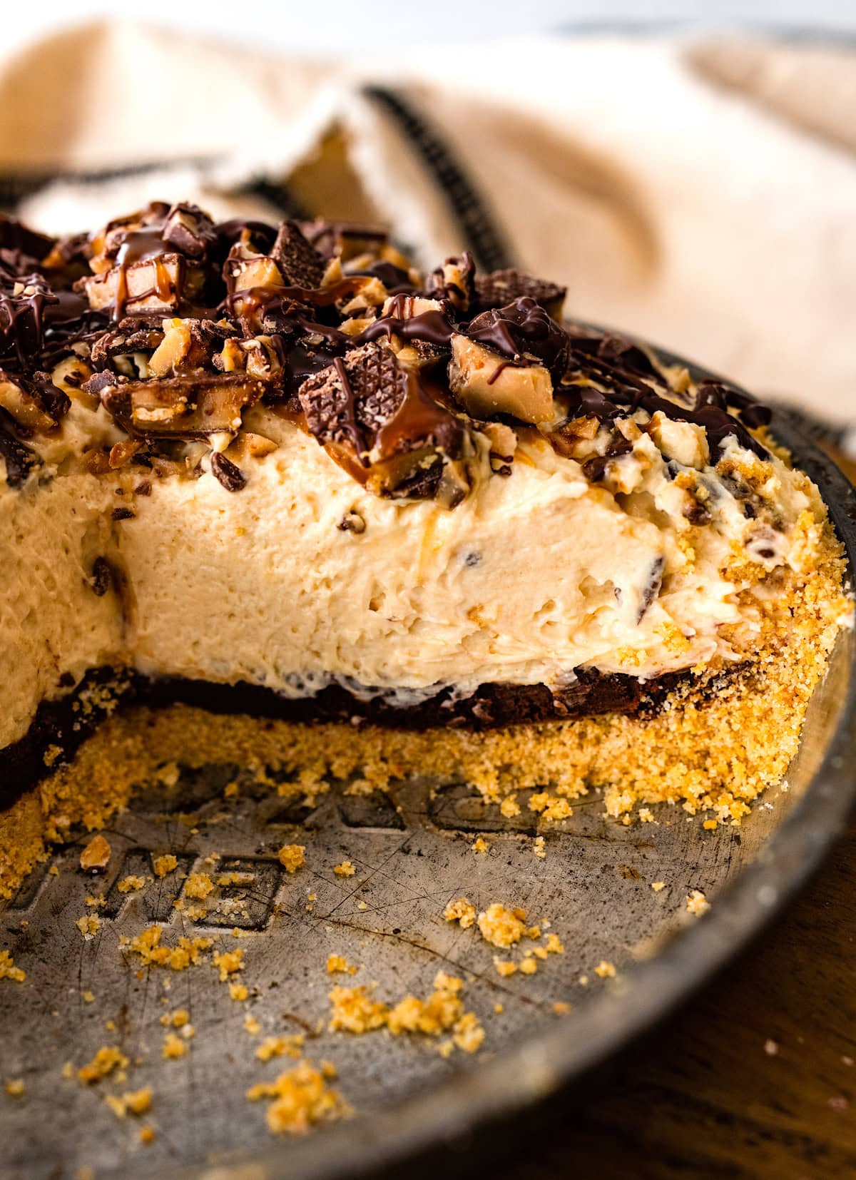 close up of salted caramel toffee pie with graham cracker crust and ganache layer. 