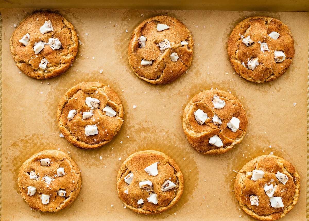 Brown Butter White Chocolate Candied Pecan Cookies on baking sheet with parchment paper. 