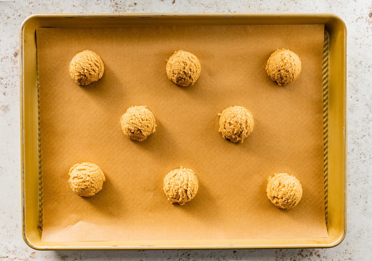 pretzel cookie dough balls on baking sheet with parchment paper. 