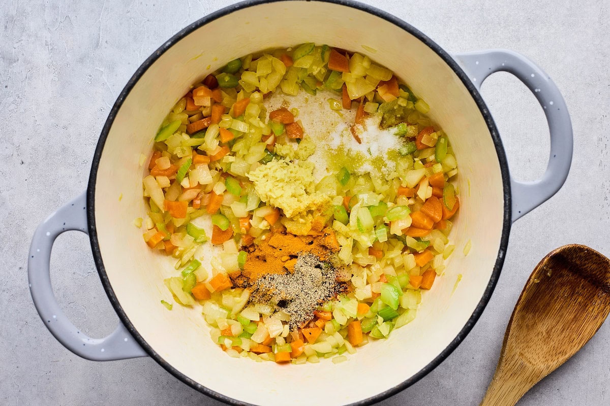 carrots, celery, onion, garlic, and spices cooking in pot. 