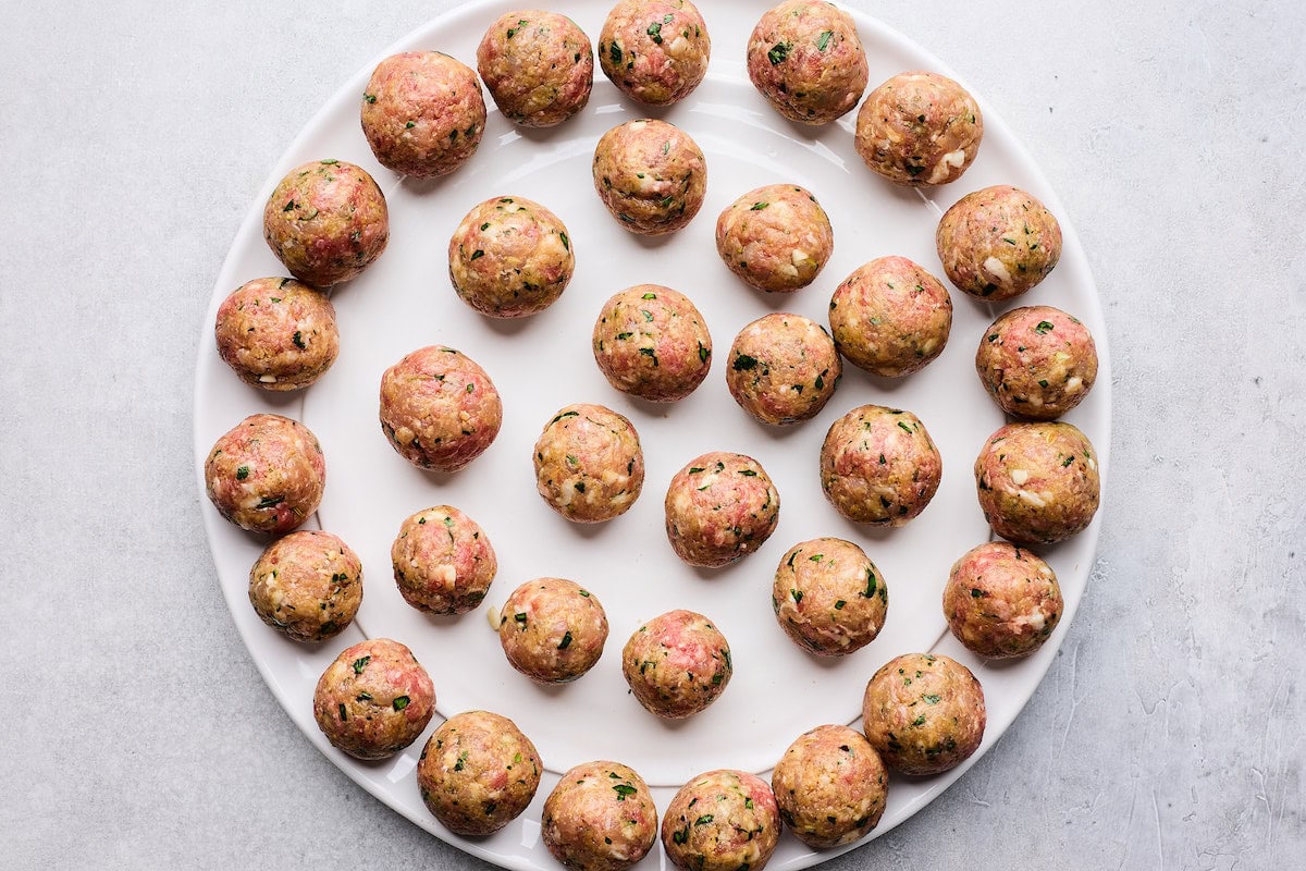 meatballs on plate ready to be cooked. 