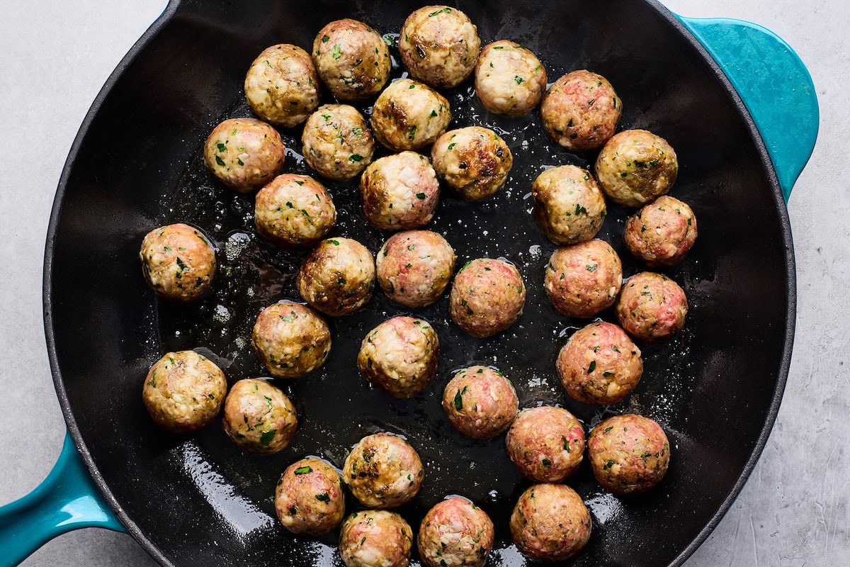 meatballs cooking in skillet. 