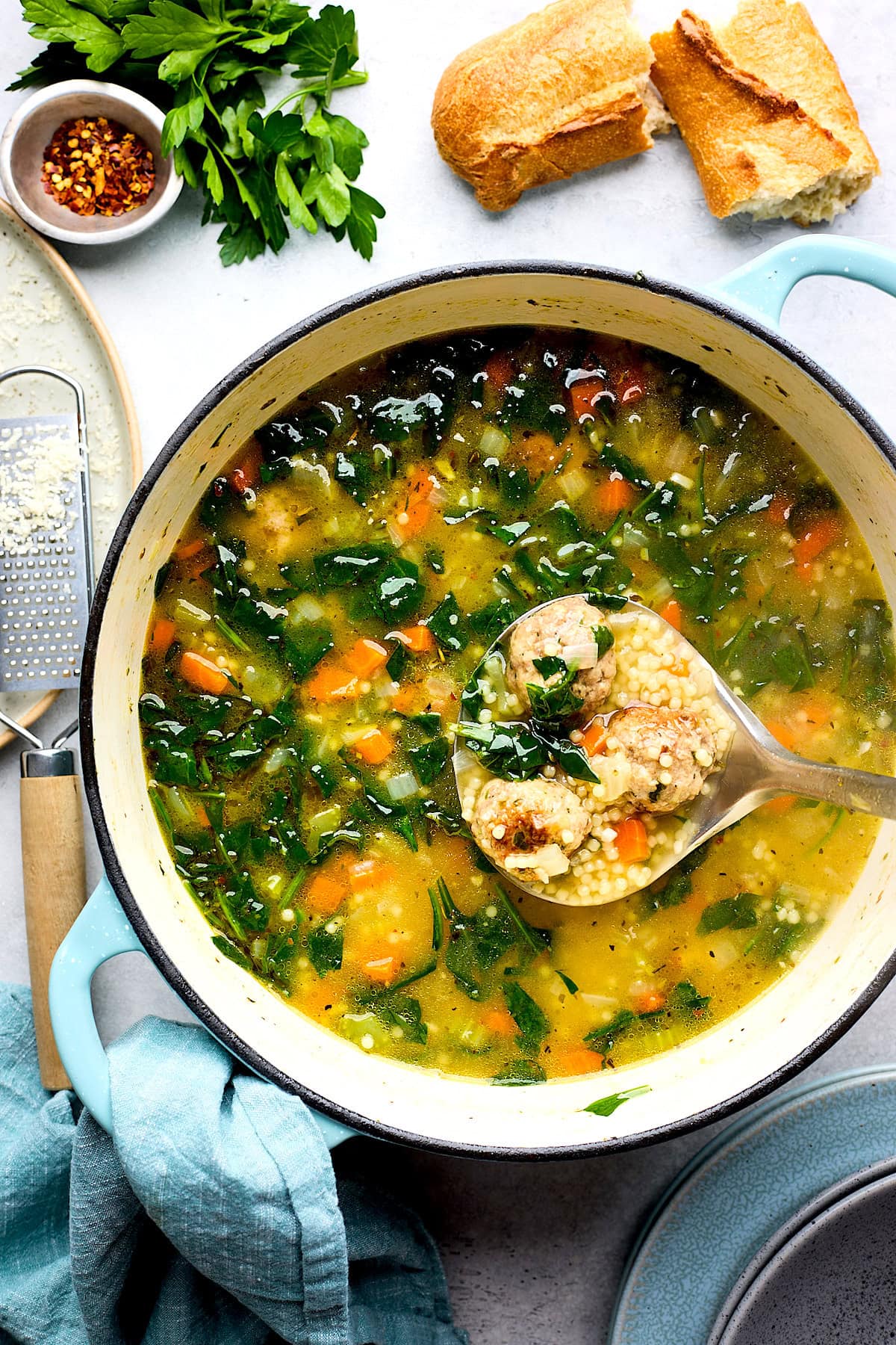 a ladle dipping into a pot of Italian wedding soup. 