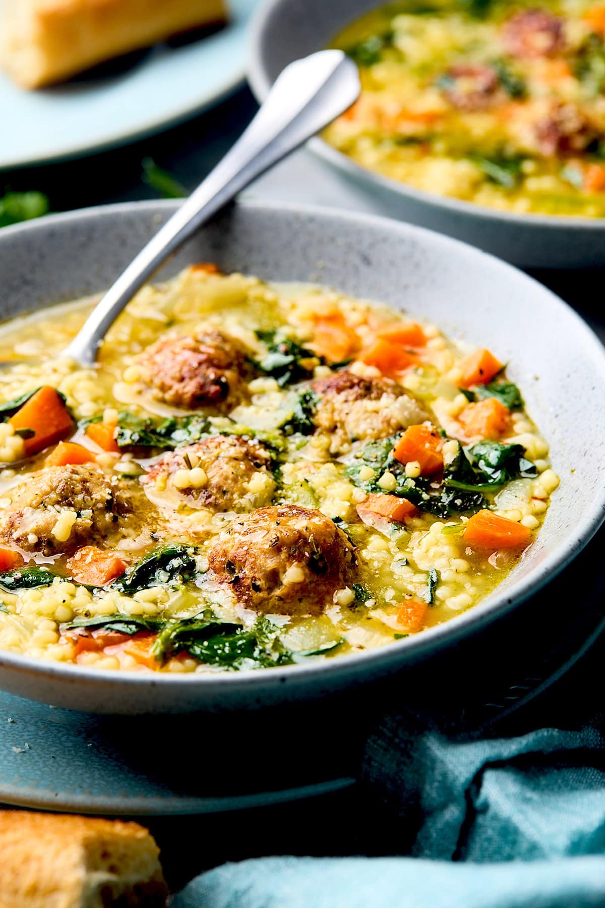 A bowl of Italian wedding soup with meatballs. 