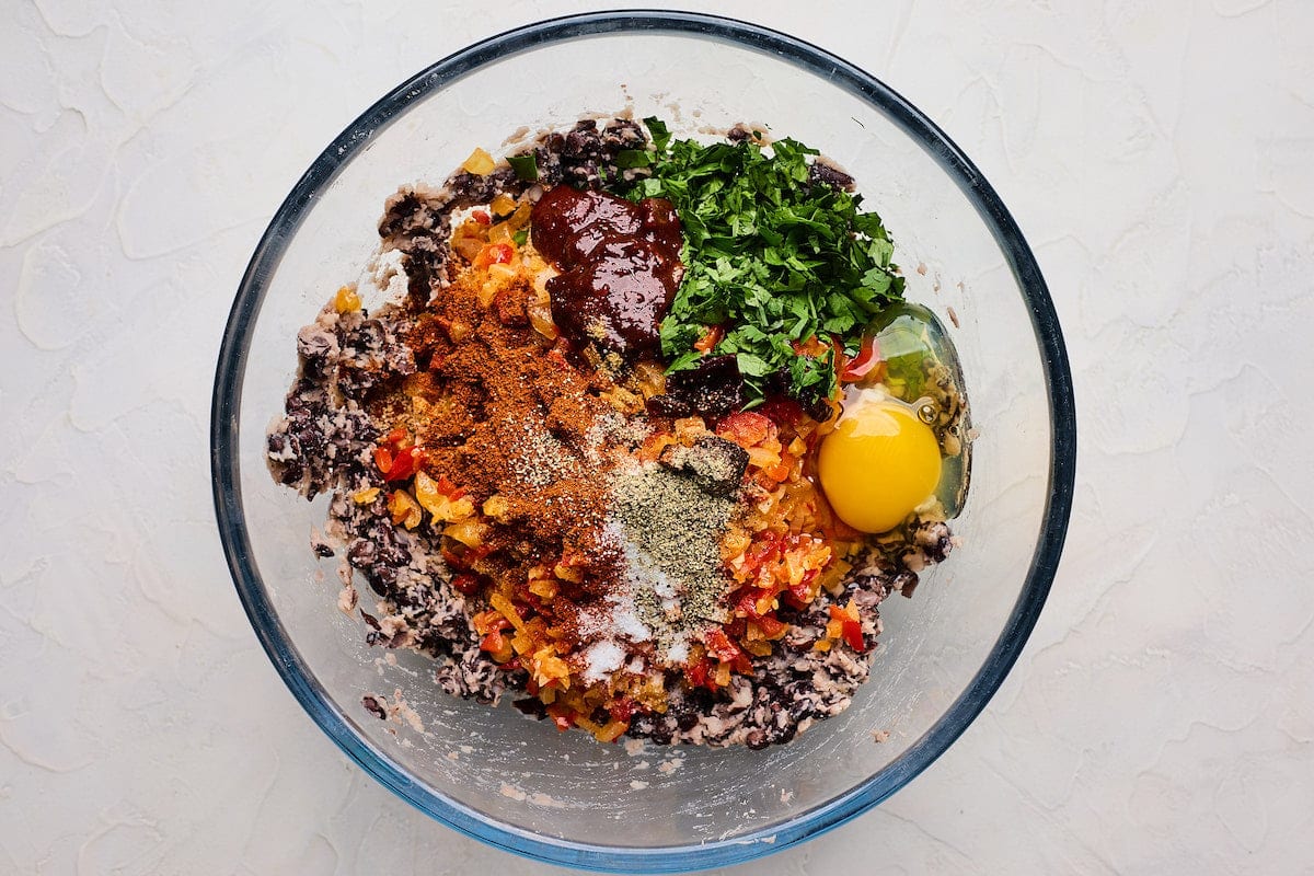 black bean mixture with spices, herbs, and egg in bowl to make black bean burger. 