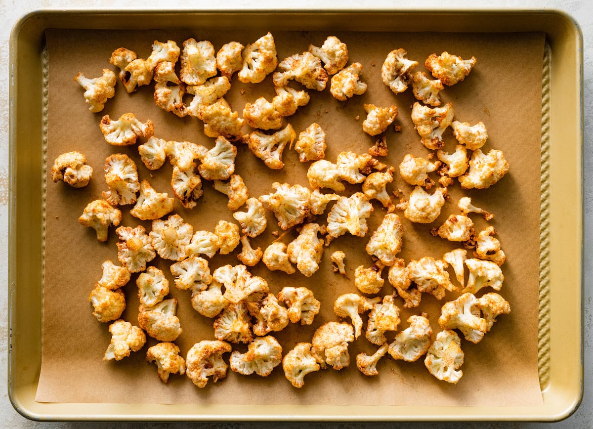 spiced cauliflower on baking sheet with parchment paper. 