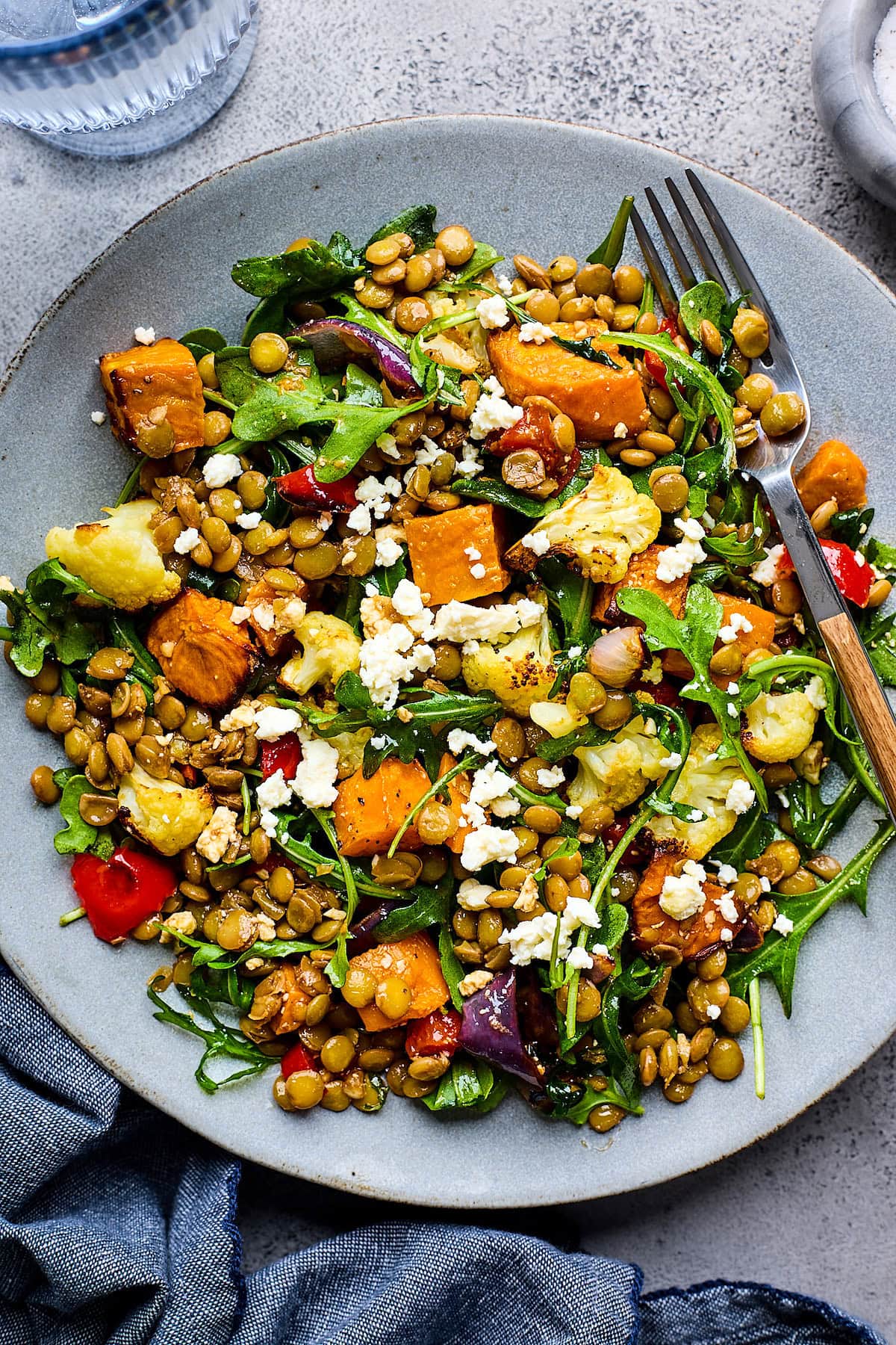 roasted vegetable lentil salad on plate with fork. 