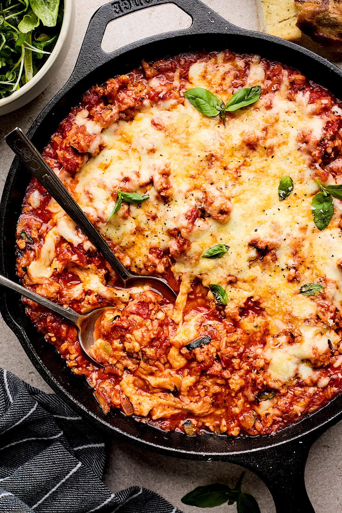 close up of Cheesy Ground Turkey Rice Skillet with Marinara Sauce with serving spoon. 