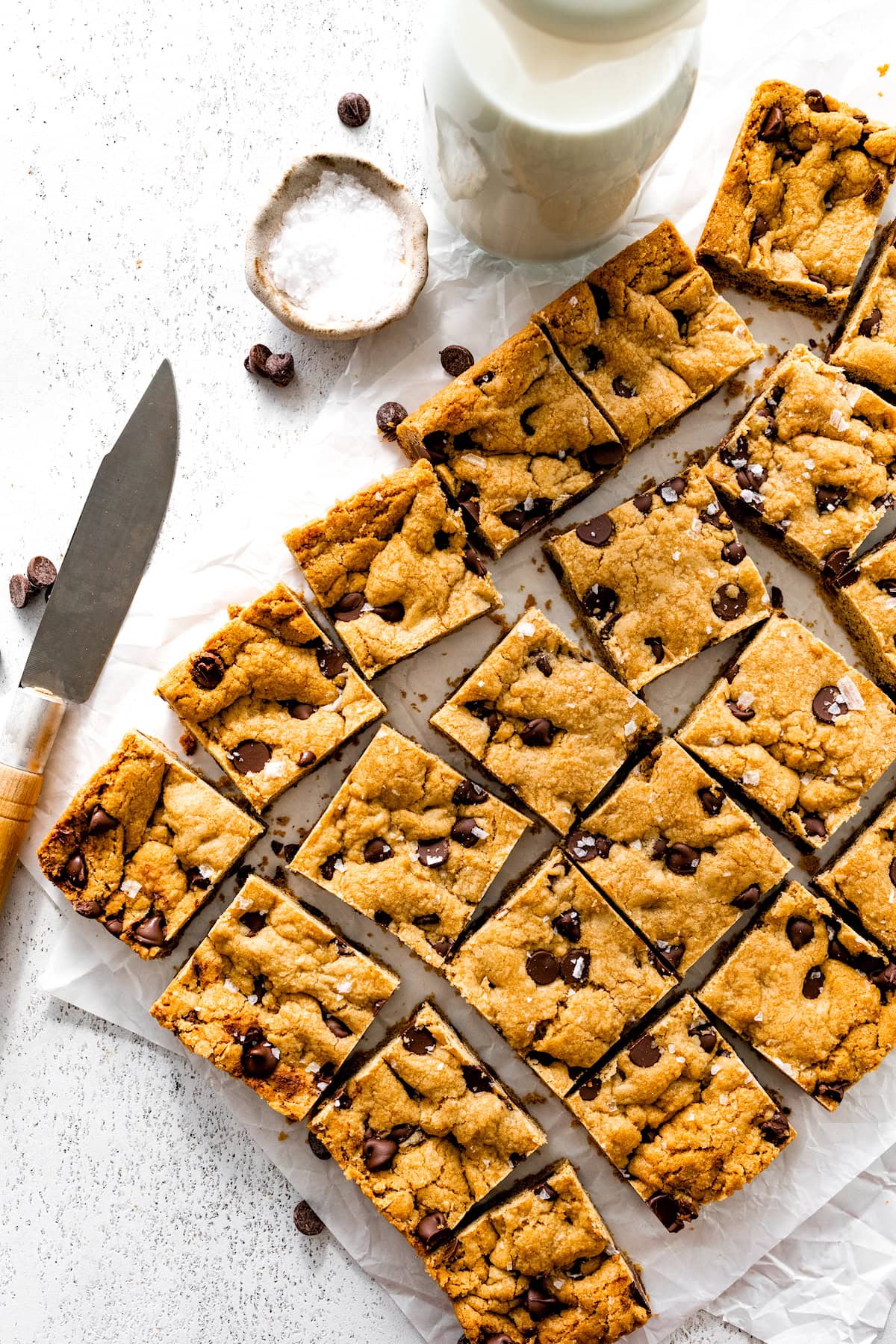 chocolate chip cookie bars cut into squares topped with flaky sea salt. 