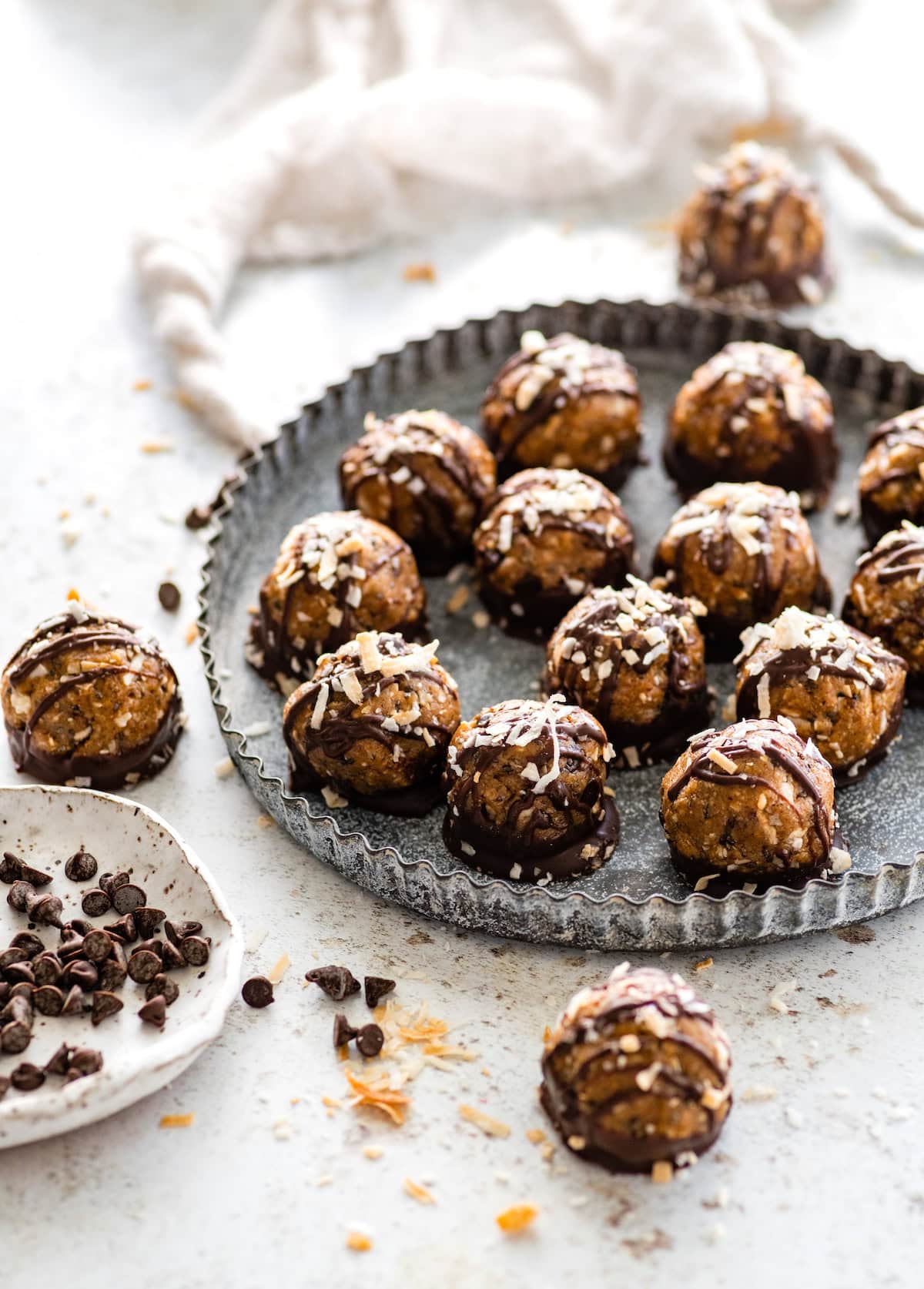 Samoa cookie protein balls on tray with toasted coconut and chocolate chips. 