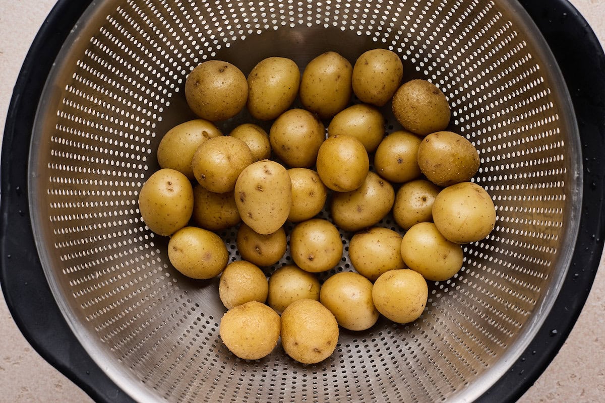 cooked baby Yukon gold potatoes in strainer. 